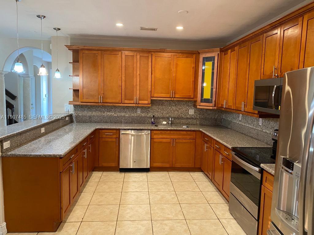 13426 Southwest 177th Terrace Miami, FL 33177 - Photo 8 of 36 a kitchen with stainless steel appliances granite countertop a sink stove and refrigerator