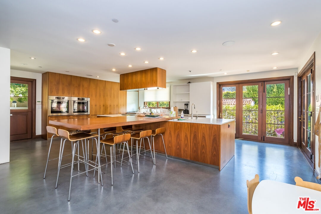 604 Alta Drive Beverly Hills, CA 90210 - Photo 6 of 21 a kitchen with a table and chairs