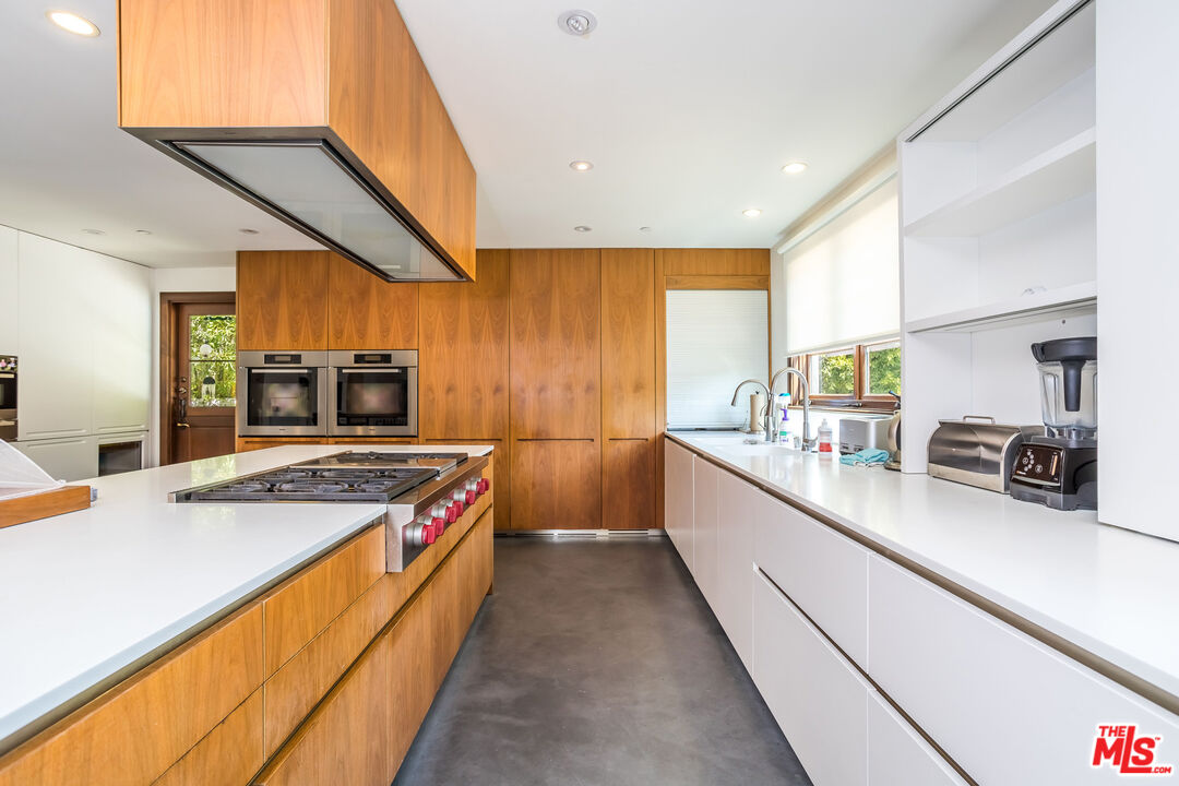 604 Alta Drive Beverly Hills, CA 90210 - Photo 7 of 21 a kitchen with stainless steel appliances a sink and a stove