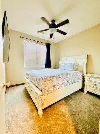 a bed room with a bed and a ceiling fan