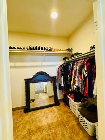 a view of walk in closet with clothes and shoes