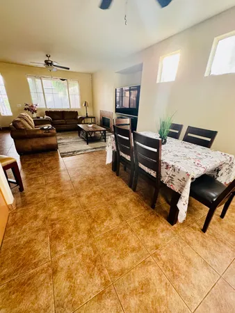 a living room with furniture stove and kitchen view