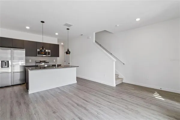 a view of kitchen with microwave and refrigerator