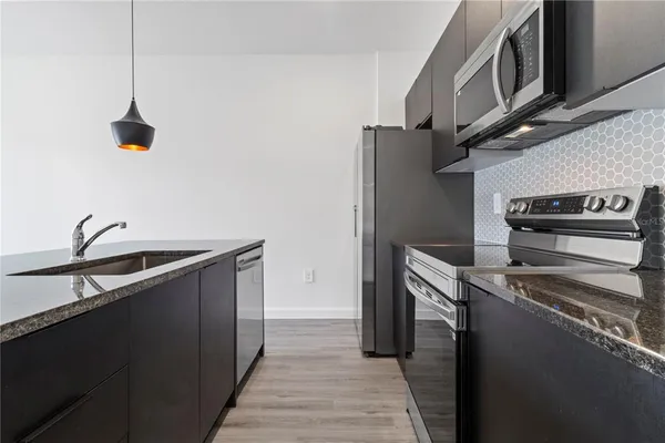 a kitchen with stainless steel appliances granite countertop a sink and a stove