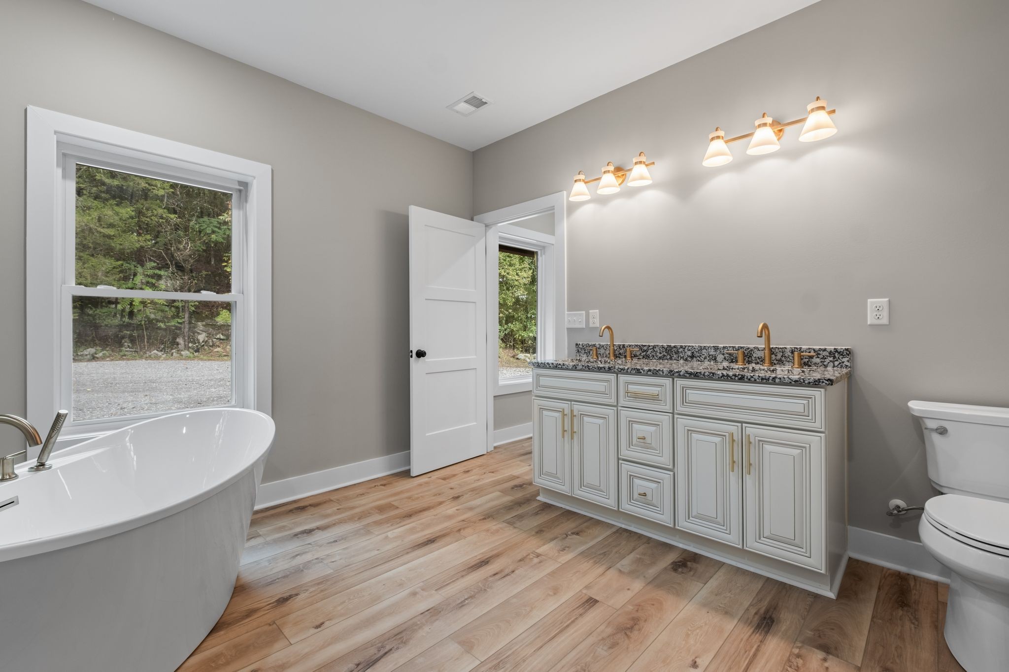 672 Sullivan Bend Road Elmwood, TN 38560 - Photo 23 of 39 a spacious bathroom with a granite countertop double vanity sink a mirror and a toilet