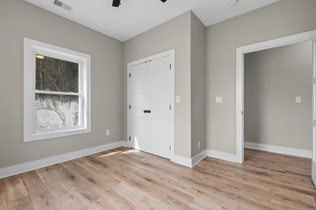 an empty room with wooden floor and windows