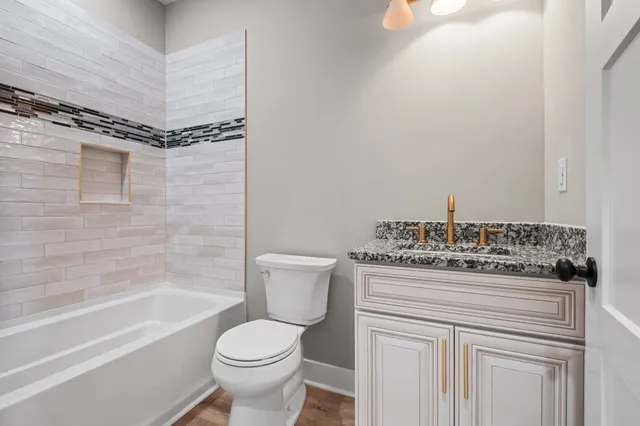 a bathroom with a granite countertop toilet sink and shower