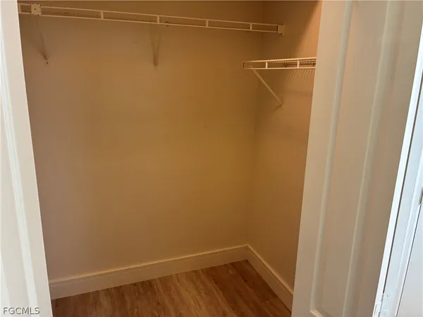 a view of a room with wooden floor and small window
