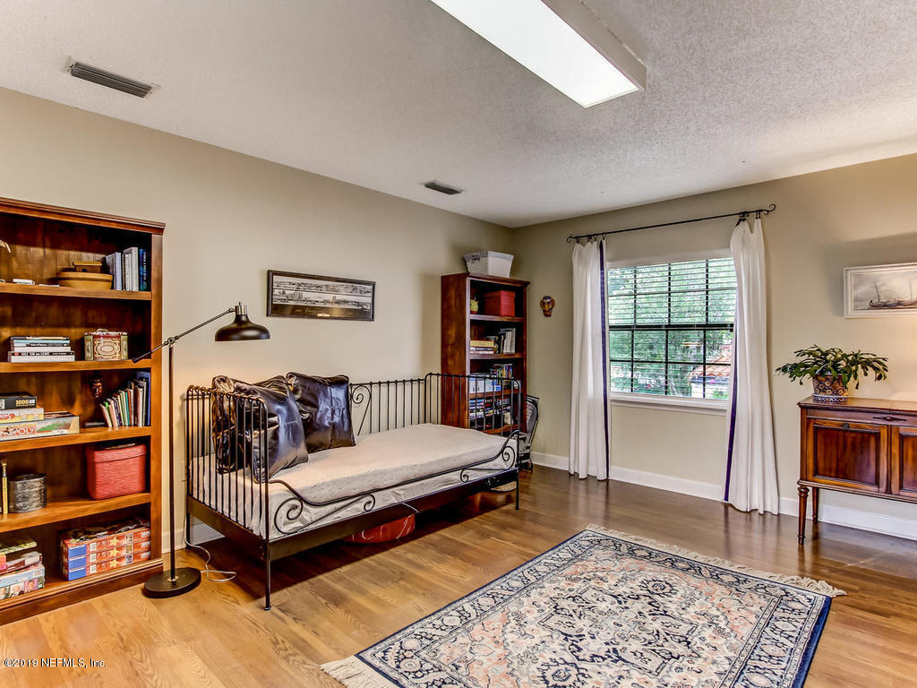 1036 Elder Lane Jacksonville, FL 32207 - Photo 67 of 79 a bedroom with furniture and a book shelf