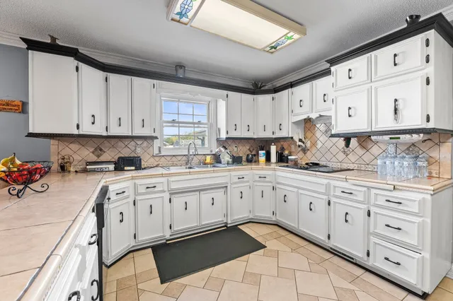a kitchen with white cabinets and refrigerator