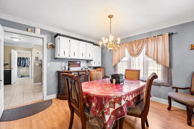 a dining room with furniture a chandelier and wooden floor