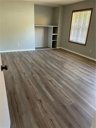 an empty room with wooden floor and window
