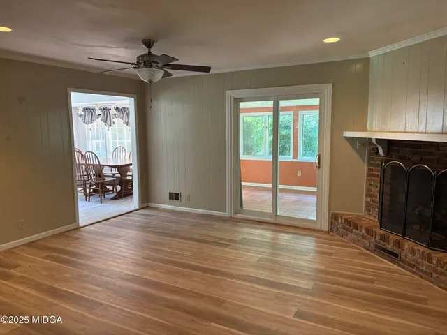 a view of an empty room with a window and a fireplace