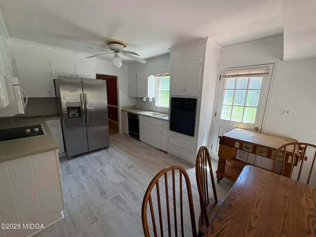 a kitchen with granite countertop a refrigerator a stove a sink dishwasher and wooden floor