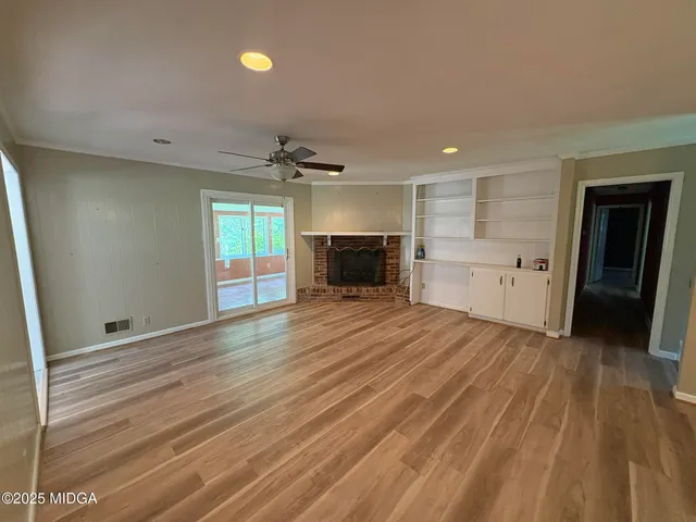 wooden floor in an empty room with a kitchen