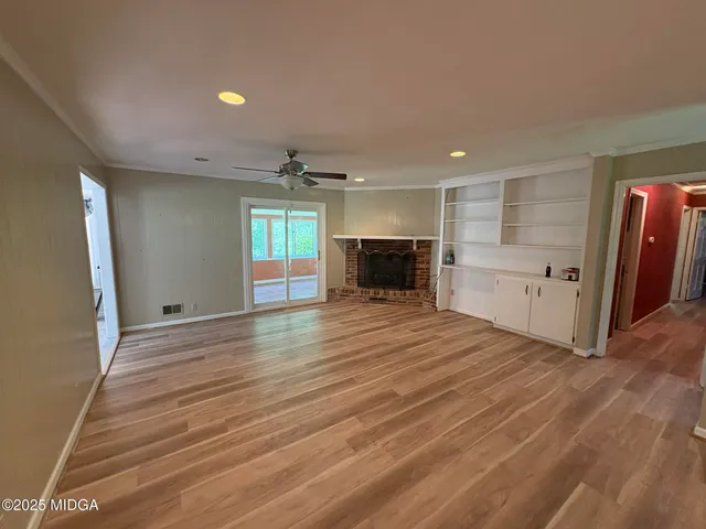 an empty room with wooden floor and fireplace