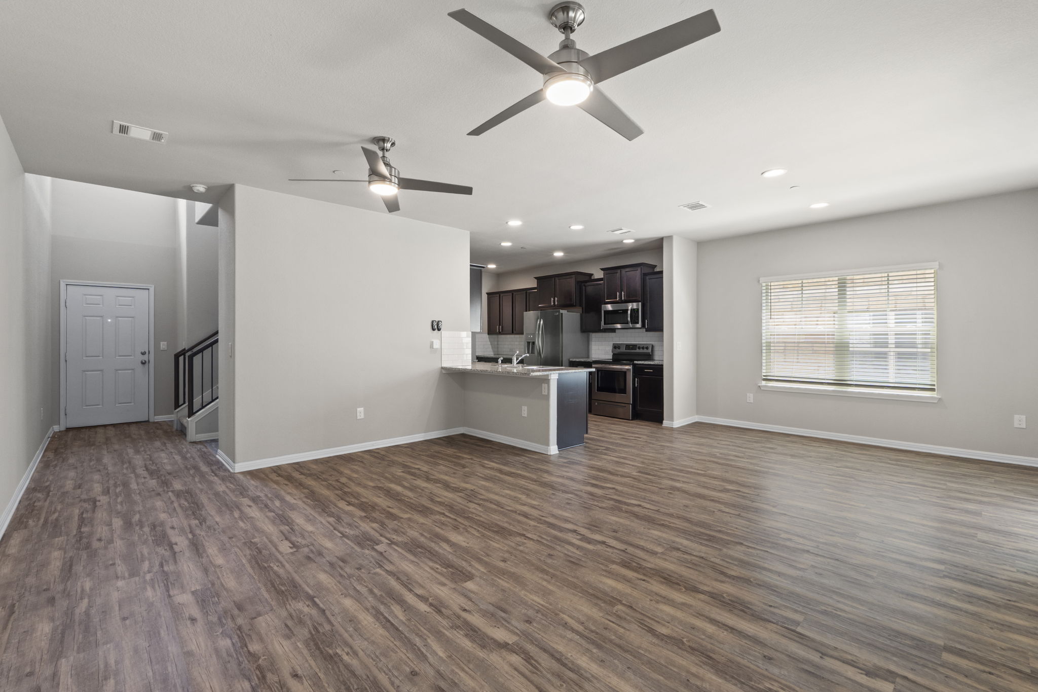 516 East Slaughter Lane, Unit 2001 Austin, TX 78744 - Photo 12 of 31 Open-concept living area featuring wood-look flooring, light gray walls, and recessed lighting