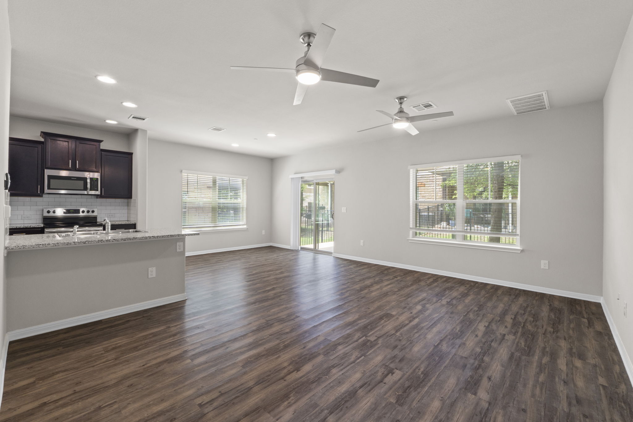 516 East Slaughter Lane, Unit 2001 Austin, TX 78744 - Photo 13 of 31 Open concept living area with wood-look flooring, recessed lighting, and ceiling fans