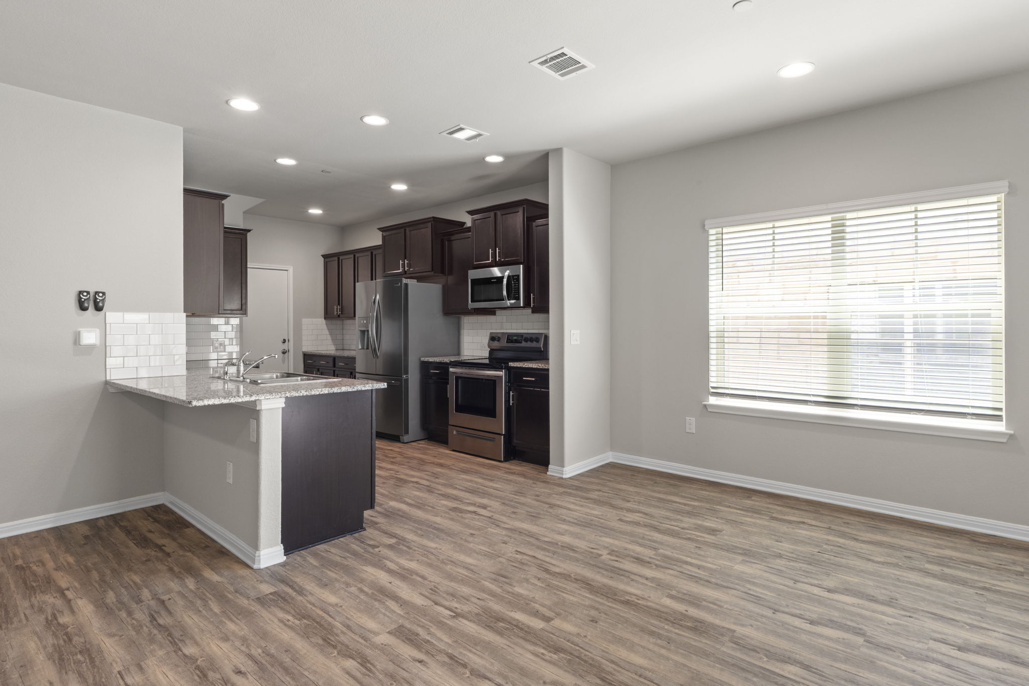 516 East Slaughter Lane, Unit 2001 Austin, TX 78744 - Photo 15 of 31 The kitchen features dark wood cabinetry, stainless steel appliances, and a light-colored countertop with a subway tile backsplash