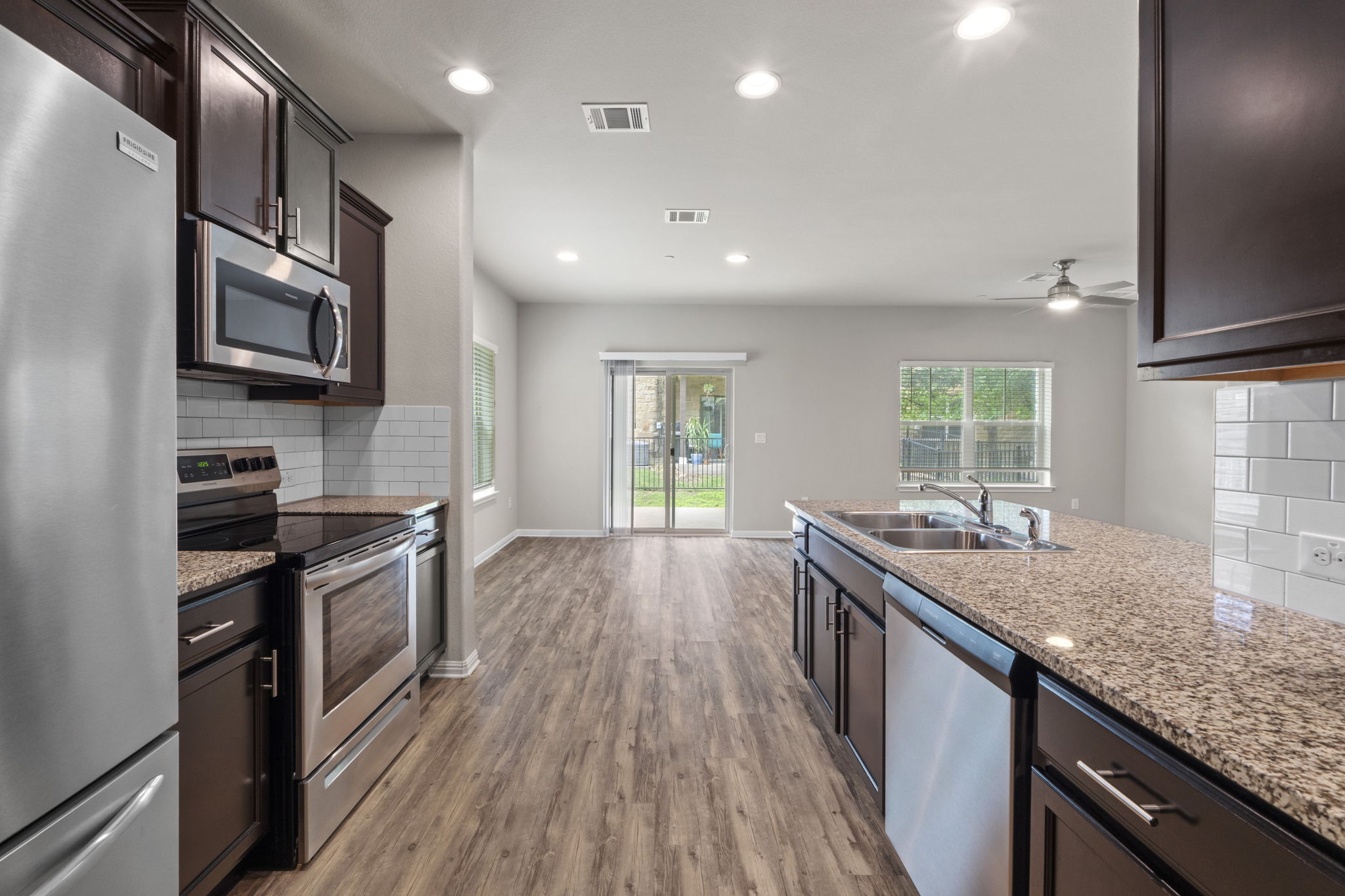 516 East Slaughter Lane, Unit 2001 Austin, TX 78744 - Photo 18 of 31 The kitchen features dark wood cabinetry, stainless steel appliances, and granite countertops