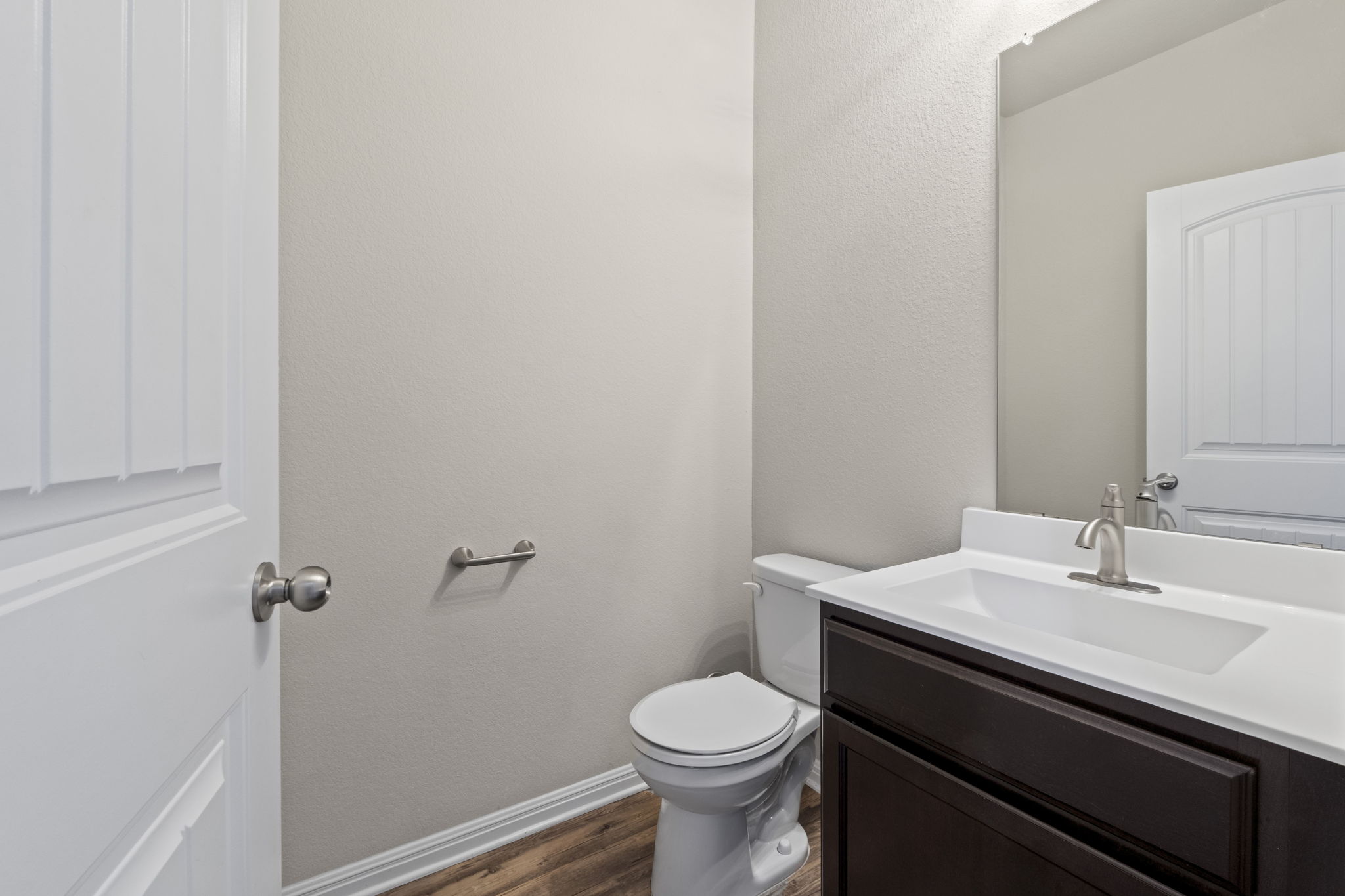 516 East Slaughter Lane, Unit 2001 Austin, TX 78744 - Photo 19 of 31 The bathroom features a vanity with a white countertop and a dark wood cabinet, a toilet, and a mirror