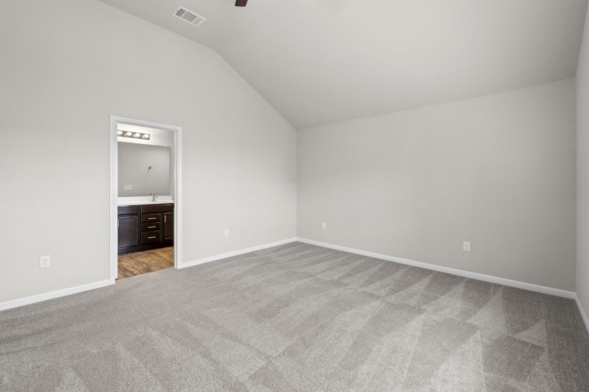 516 East Slaughter Lane, Unit 2001 Austin, TX 78744 - Photo 23 of 31 Spacious room with vaulted ceilings, light gray walls, and gray carpet