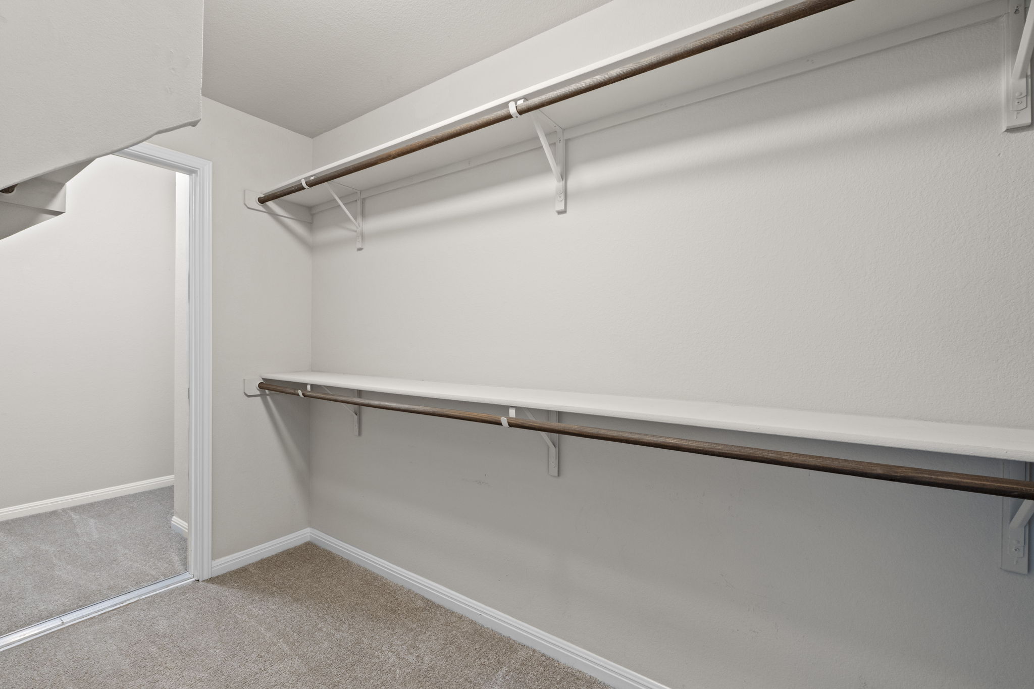 516 East Slaughter Lane, Unit 2001 Austin, TX 78744 - Photo 25 of 31 The property features a closet with built-in shelving and hanging rods, light-colored carpeting, and a mirrored closet door