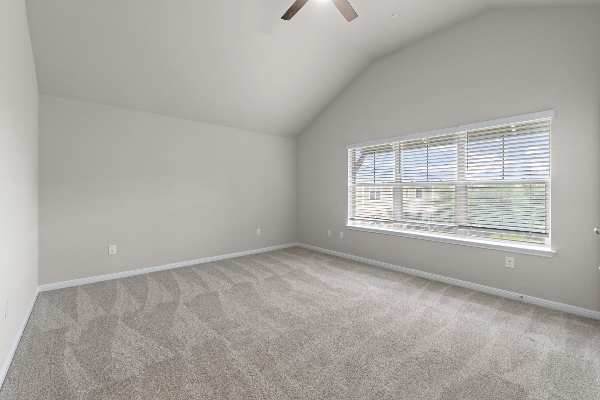 516 East Slaughter Lane, Unit 2001 Austin, TX 78744 - Photo 26 of 31 This spacious room features vaulted ceilings, ample natural light from a large window with blinds, and patterned carpeting