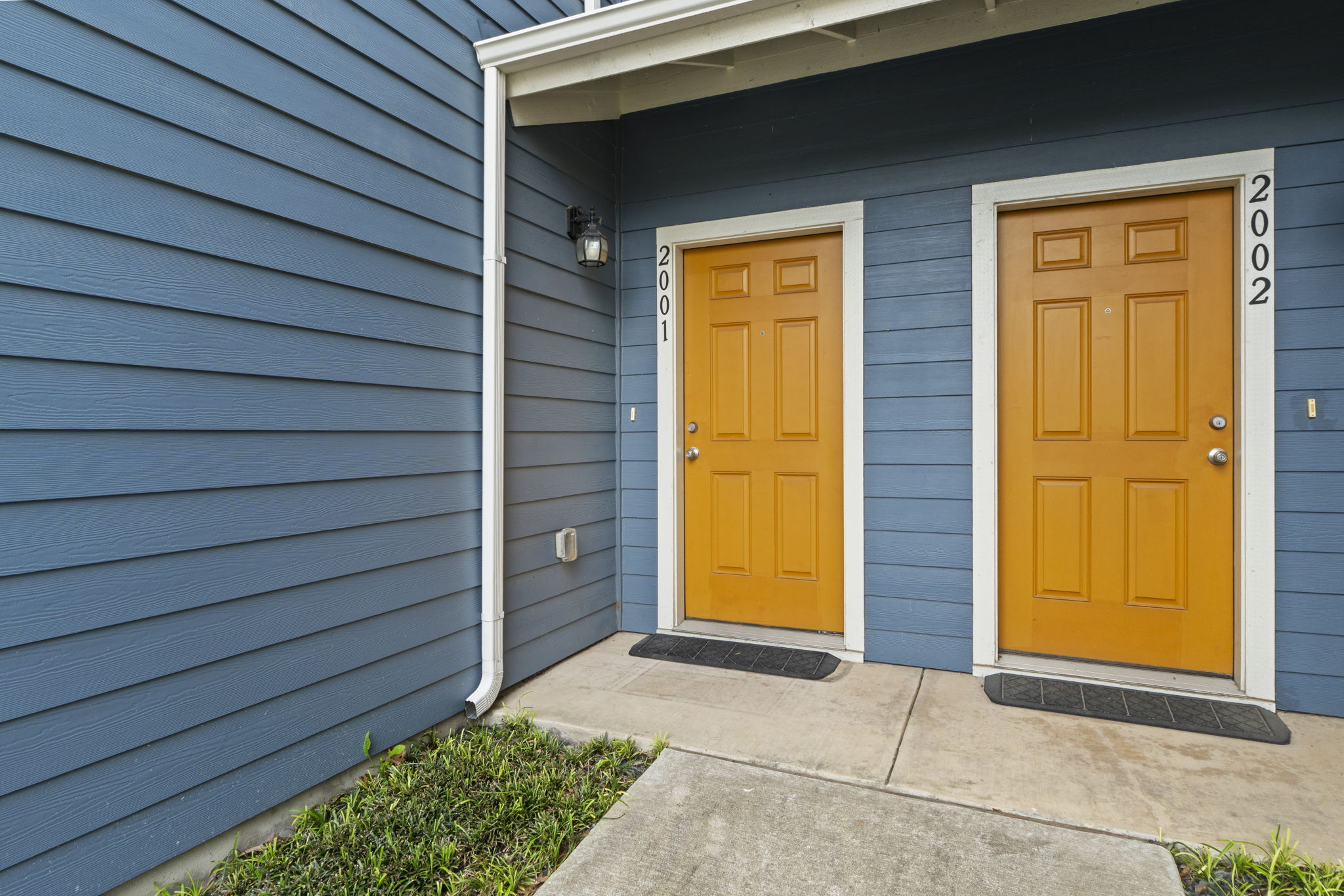 516 East Slaughter Lane, Unit 2001 Austin, TX 78744 - Photo 9 of 31 The property features a blue exterior with contrasting yellow entry doors, each with a light-colored trim
