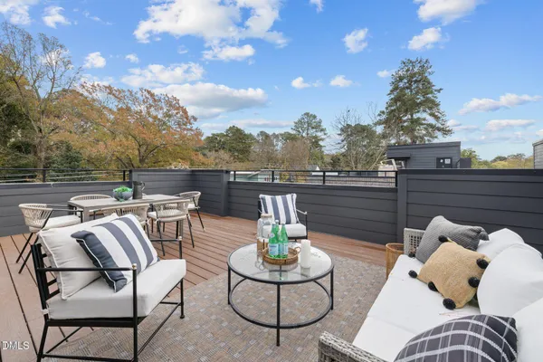 a view of a roof deck with couches and potted plants