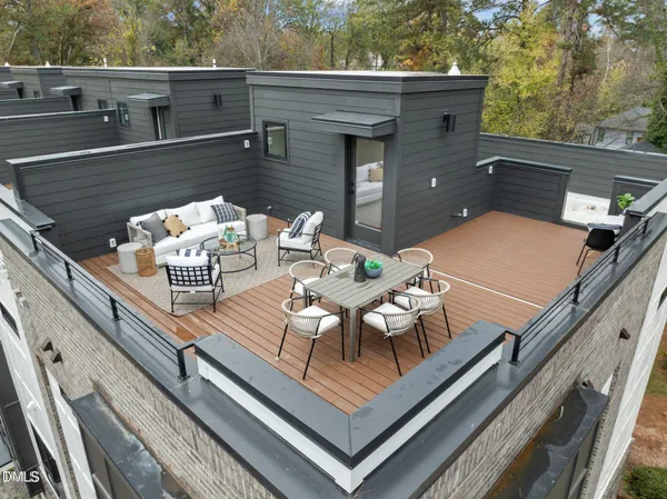 a roof deck with couches and wooden floor