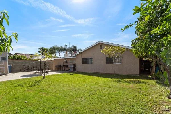 a view of a house with a yard and palm trees