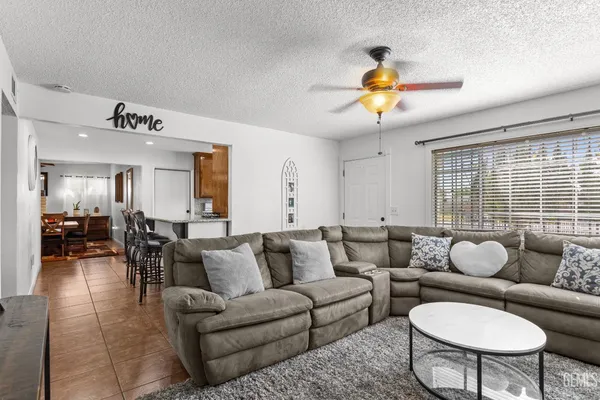 a living room with furniture a dining table and a chandelier
