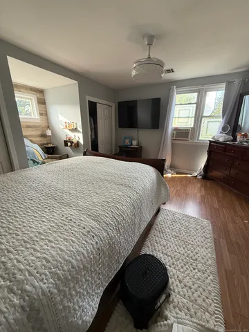 a bedroom with a bed and wooden floor