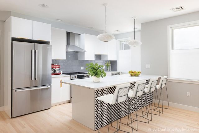 a kitchen with stainless steel appliances granite countertop a refrigerator a sink a stove a dining table and chairs