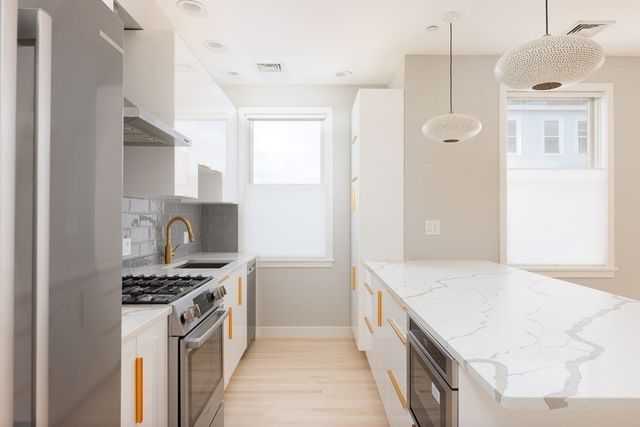 a kitchen with stainless steel appliances granite countertop a stove and a refrigerator