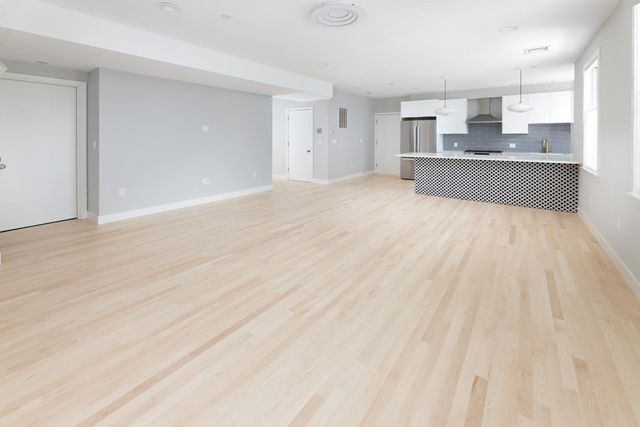 a large white kitchen with kitchen island a sink wooden floor and counter top space
