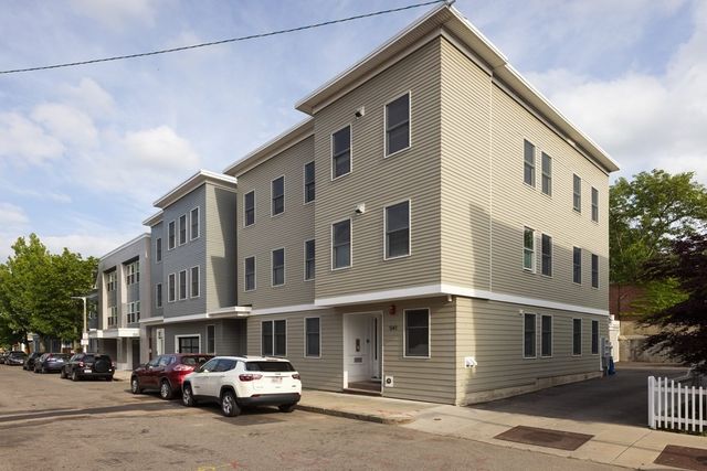 a couple of cars parked in front of a building