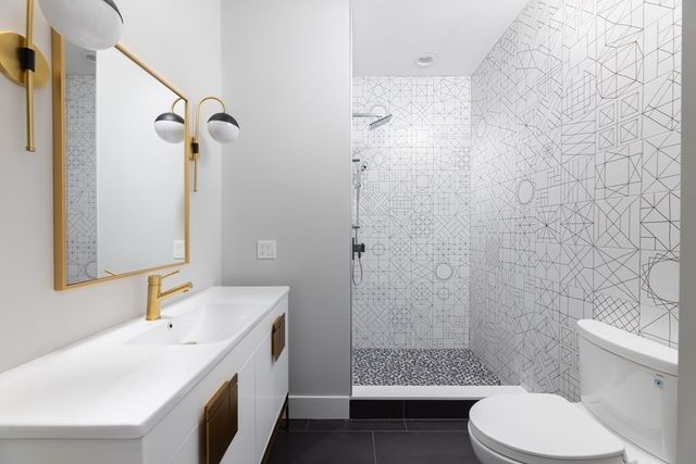 a bathroom with a sink a toilet and shower