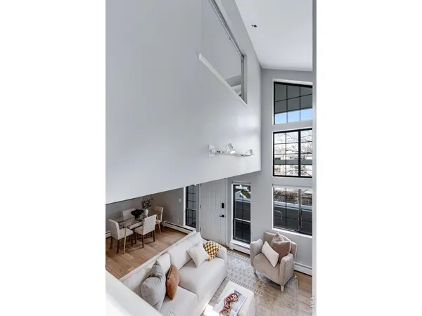 a kitchen with stainless steel appliances granite countertop a refrigerator a stove a sink a dining table and chairs with wooden floor