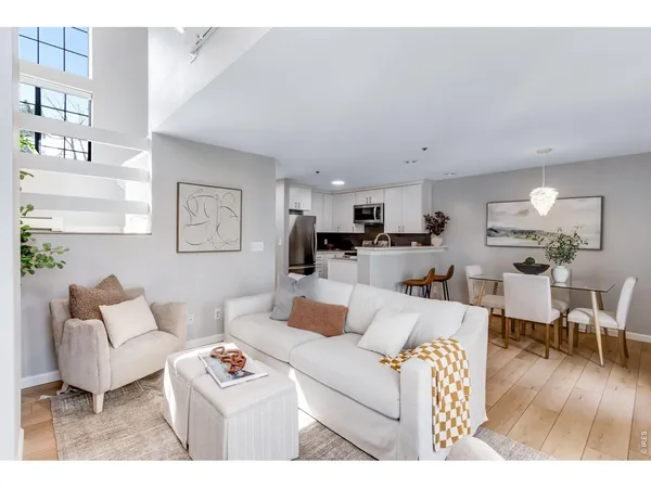 a living room with furniture a wooden floor and a dining table