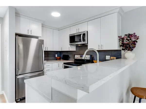 a bathroom with a sink a mirror and a potted plant