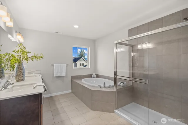 a bathroom with a tub a sink a mirror and a shower