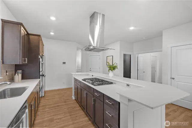 a kitchen with stainless steel appliances kitchen island granite countertop a sink stove and cabinets