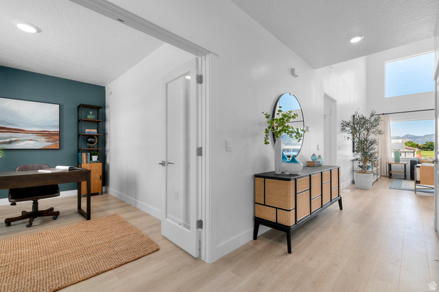 1418 West 2350th South, Unit 15 Perry, UT 84302 - Photo 2 of 22 Spacious hallway with light wood-finish flooring and high ceilings, featuring a dedicated room with a contrasting accent wall and recessed lighting