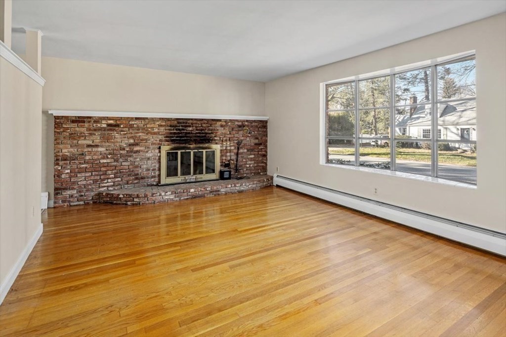 48 Fuller Road Wayland, MA 01778 - Photo 6 of 38 a view of empty room with wooden floor and fireplace