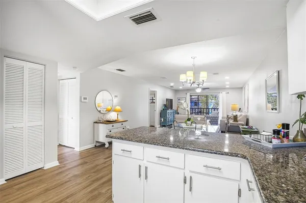 a kitchen with granite countertop a sink cabinets and wooden floor