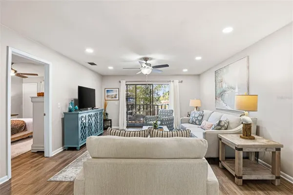 a living room with furniture a flat screen tv and a large window
