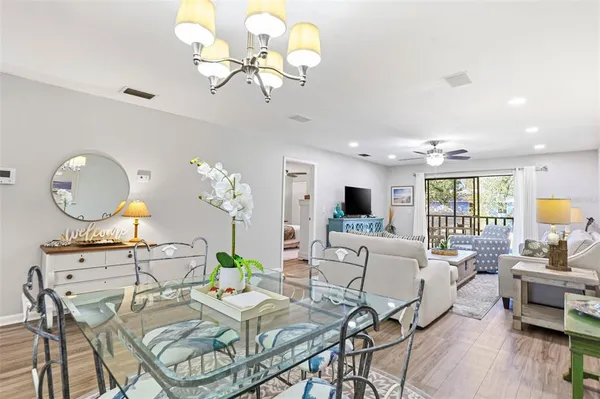 a view of a dining room with furniture a chandelier and wooden floor
