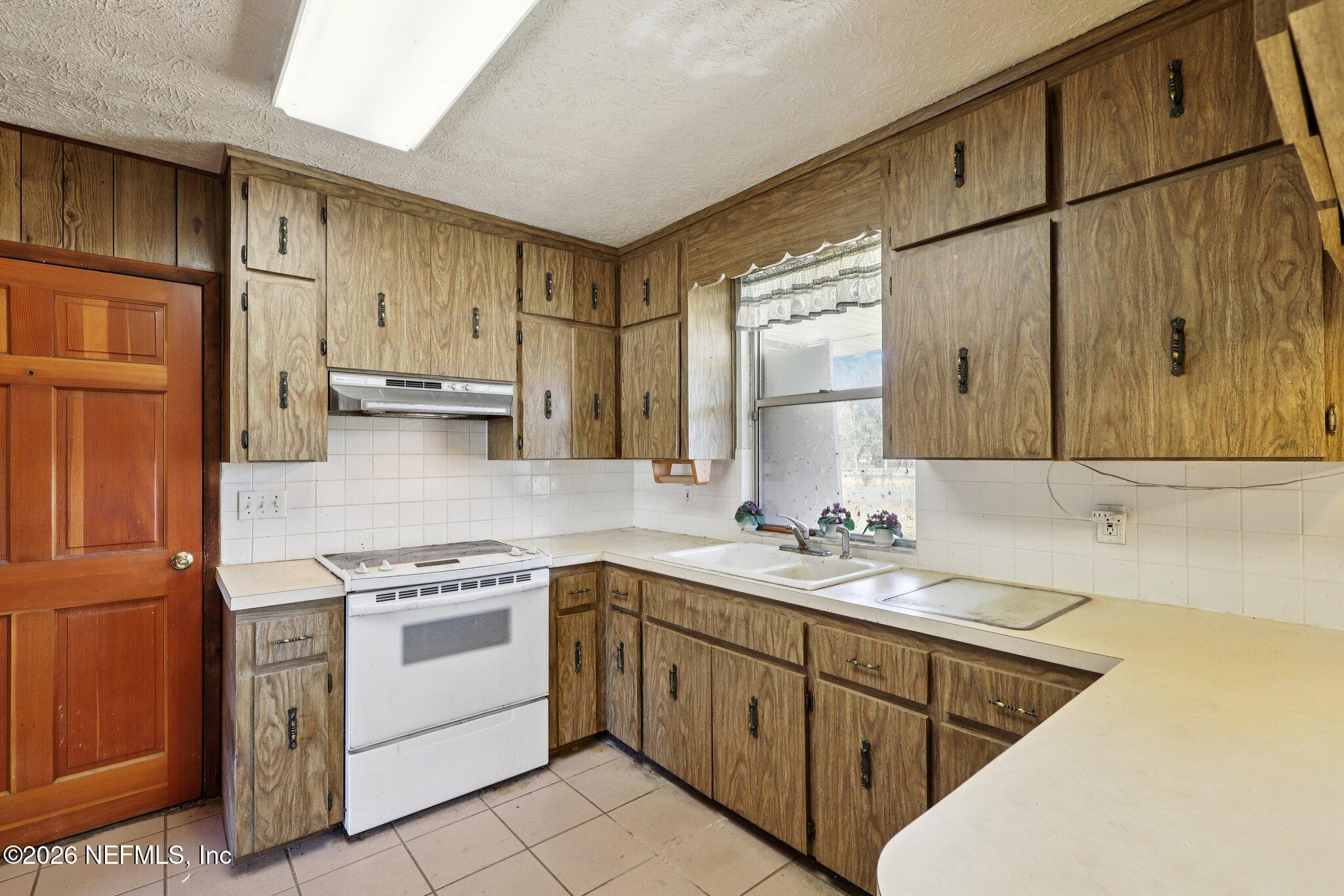 54031 Sheffield Road Callahan, FL 32011 - Photo 15 of 56 a kitchen with a sink stove and cabinets